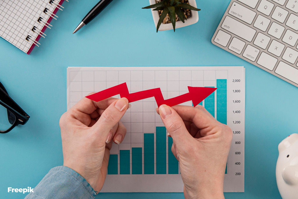 top-view-business-items-with-growth-chart-hands-holding-arrow.jpg